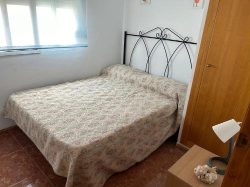 a small bedroom with a bed with a blanket at Apartamento a 200 metros de la playa de arena Les Cases en Xilxes - Castellón in Chilches