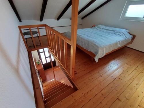a bedroom with a bed and a wooden staircase at Apartment Martina in Rab