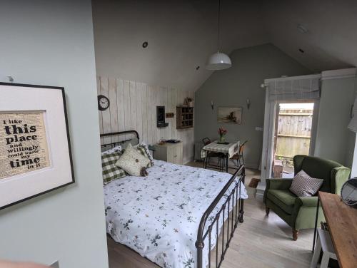 a bedroom with a bed and a green chair at The Dorm Bed and Breakfast in Eccleshall