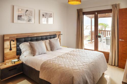 - une chambre avec un grand lit et un balcon dans l'établissement Villa 61 PlayaBlanca Lanzarote Pool Spa, à Playa Blanca