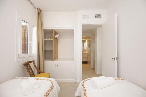 a white room with two beds and a hallway at Apartamento de tres habitaciones en Girona in Girona