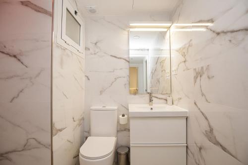 a white bathroom with a toilet and a sink at Apartamento de tres habitaciones en Girona in Girona