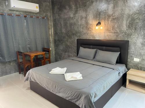 Green Mountain Resort Koh Yao في كو ياو ياي: غرفة نوم عليها سرير وفوط