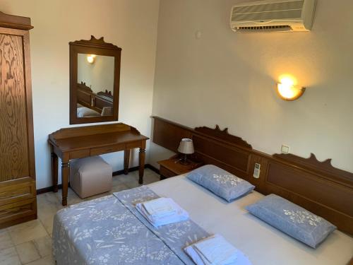 a bedroom with two beds and a desk and a mirror at Alp inn Butik Apart ve Restoran in Marmaris