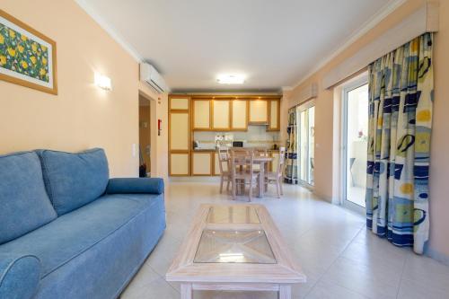a living room with a blue couch and a table at Vila Marachique Torralvor in Alvor