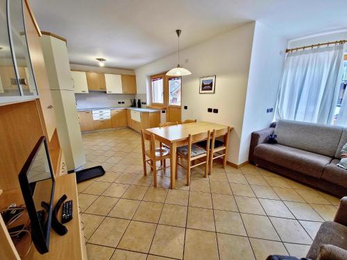 cocina y sala de estar con mesa y sofá en Alpe Di Gries Sella Ronda Dolomiti, en Canazei