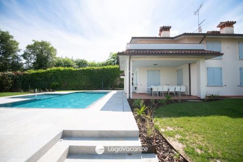 a villa with a swimming pool and a house at Exclusive Villa le Palme in Polpenazze del Garda