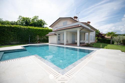 a swimming pool in front of a villa at Exclusive Villa le Palme in Polpenazze del Garda