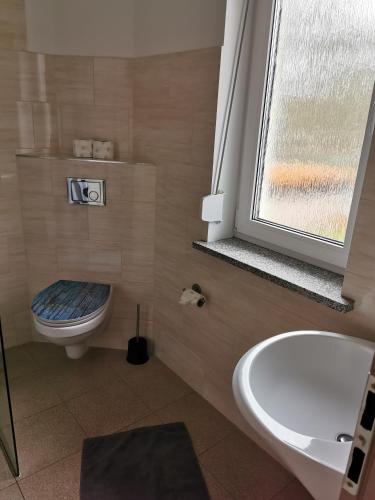 a bathroom with a toilet and a tub and a sink at Monteure sind HERZLICH WILLKOMMEN! in Mittenwalde