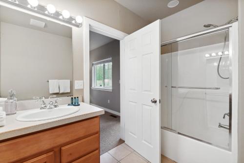 a white bathroom with a sink and a shower at Suncrest Hideaway in Whitefish