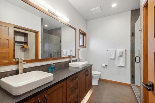 a bathroom with a sink and a mirror and a toilet at Swan Lake House in Bigfork