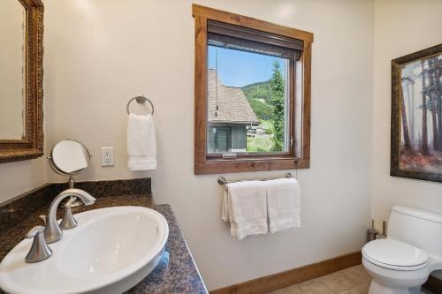 La salle de bains est pourvue d'un lavabo, de toilettes et d'une fenêtre. dans l'établissement Whitefish Ski Haus, à Whitefish