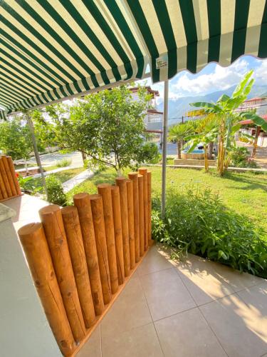 a wooden fence with an umbrella in a park at Yard Paradise in Dhërmi