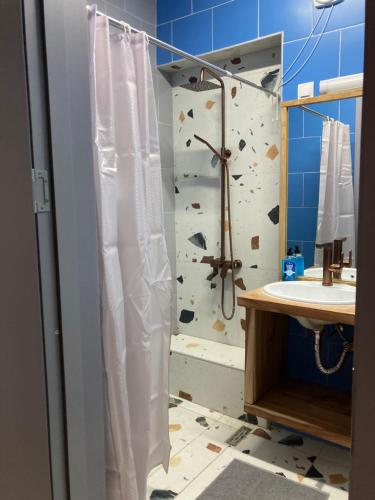 a shower curtain in a bathroom with a rock wall at Уютная квартира в Цхалтубо in Tskaltubo