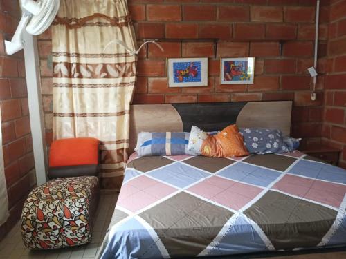 Ce lit se trouve dans une chambre dotée d'un mur en briques. dans l'établissement A orillas del paraiso, à Playas