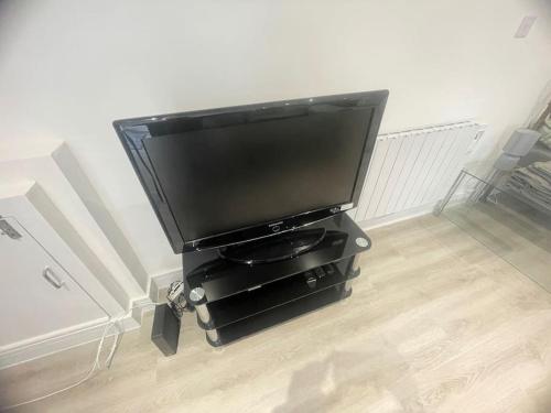 a flat screen tv sitting on a stand in a room at Private Studio near Watford Junction in Leavesden Green