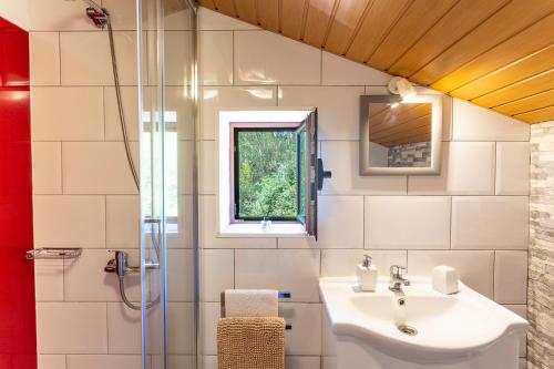 un baño con lavabo y ducha en Refúgio do Lourinho, en Funchal
