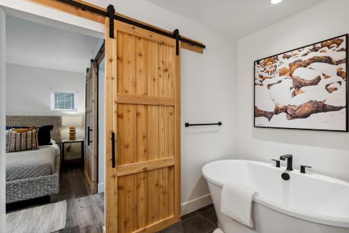 a bathroom with a wooden door and a bath tub at Quarry A35 in Whitefish