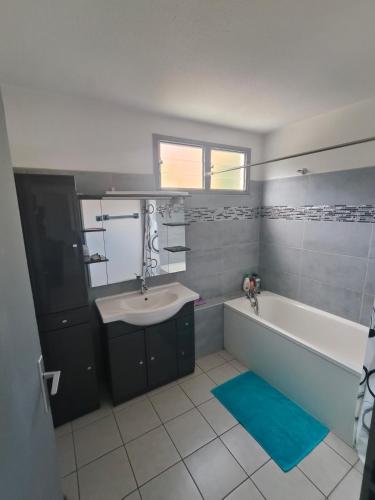 a bathroom with a tub and a sink and a bath tub at Appartement en Duplex, centre ville de Saint Leu, résidence privée in Saint-Leu