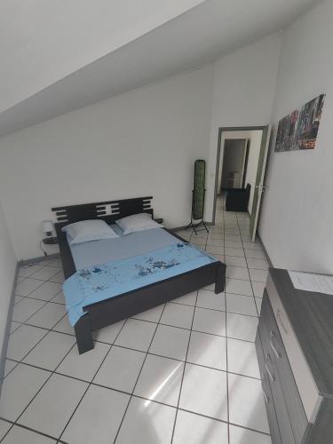 a bedroom with a bed and a tiled floor at Appartement en Duplex, centre ville de Saint Leu, résidence privée in Saint-Leu
