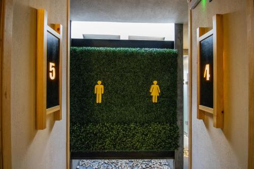a bathroom with a green wall with men on it at Hotel Aeropuerto Tuxtla Gutierrez Ernesto Garcia in Chiapa de Corzo