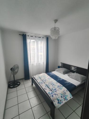 a bedroom with a bed and a fan at Appartement en Duplex, centre ville de Saint Leu, résidence privée in Saint-Leu
