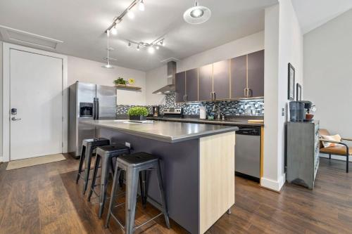 a kitchen with a large counter and stools in it at Frisco Stay- 0 1Mi to MTB trail Walk to DT Fay in Fayetteville