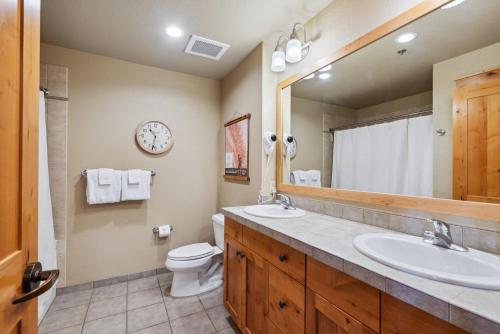 Un baño con lavabo, inodoro y espejo. en Morning Eagle 207, en Whitefish