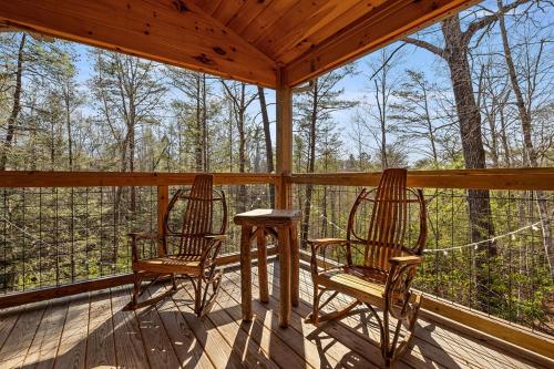 two chairs and a table on the porch of a cabin at Bobcat Den by Eden Crest in Gatlinburg
