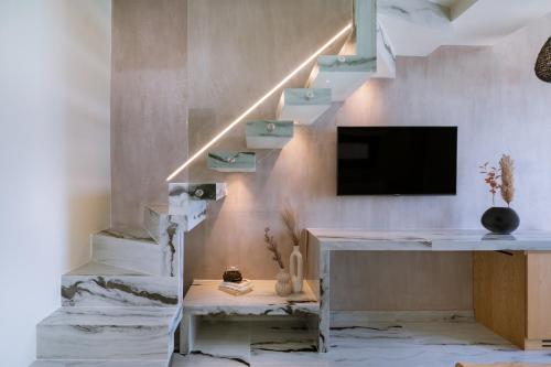 a room with a desk and a tv and stairs at ZEST THASSOS LUXURY RETREAT in Limenaria