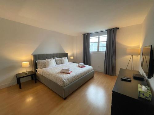 阳光岛滩Stunning apt! Oceanview! Parking included的卧室里有一张床和一台电视机