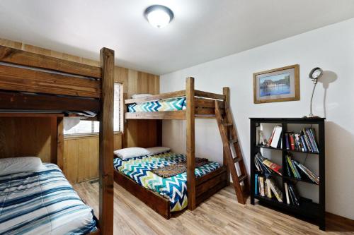 a bedroom with two bunk beds and a book shelf at Mountain Charm in Homewood