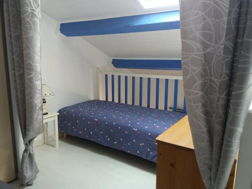une chambre avec un lit et un baldaquin bleu et blanc dans l'établissement Port Leucate - Maison 4 personnes, à Port-Leucate