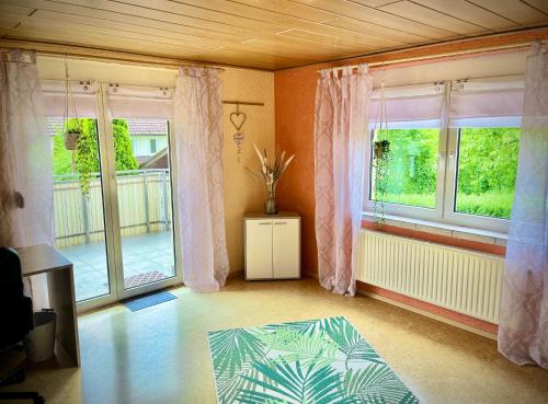 Sala de estar con 2 ventanas y mesa en neXt doOr Donau Gästezimmer und Suite en Wurmlingen