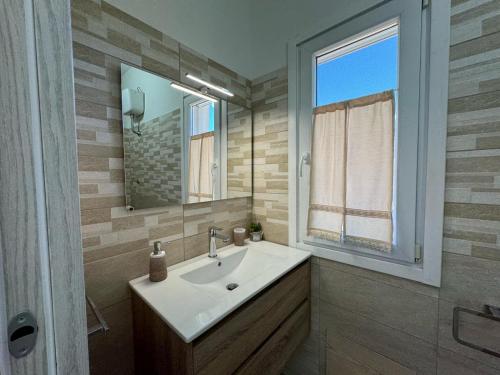 een badkamer met een wastafel en een spiegel bij B&B Sensorial Experience in Villamassargia