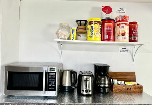 a kitchen counter top with a microwave and coffee makers at Cozy Private Room with Shared Bathroom on the 1st Floor - Conveniently Located near SeaTac Airport and Downtown in Seattle