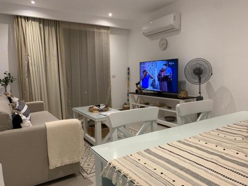 ein Wohnzimmer mit Sofa und Fernseher in der Unterkunft Caesar Bay Resort Ras Al Hekma in Dawwār Abū Duray‘ah ‘Abd al Karīm