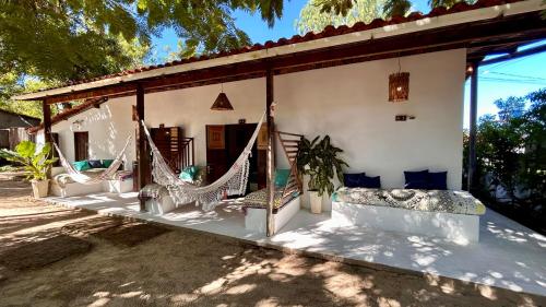 a porch of a house with hammocks on it at Pousada Maresia in Atins