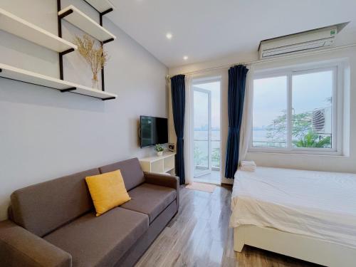 a living room with a couch and a large window at Hanoi Home 2 - Lake View Apartment in Hanoi