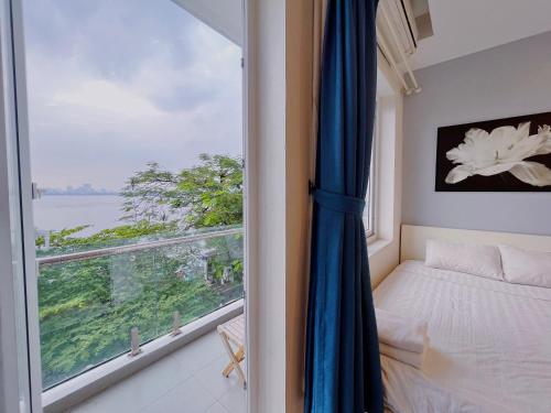 a bedroom with a window with a bed and a view at Hanoi Home 2 - Lake View Apartment in Hanoi