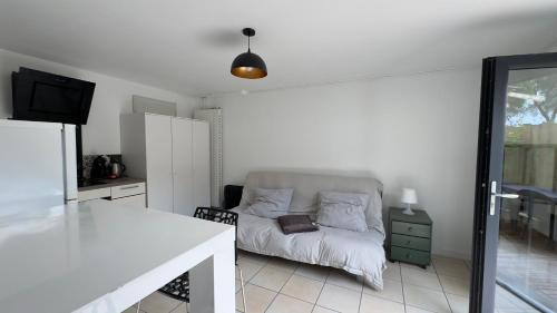 un salon blanc avec un canapé et une table dans l'établissement Studio centre Seignosse, à Seignosse