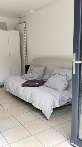 un lit avec des draps blancs et des oreillers dans une chambre dans l'établissement Studio centre Seignosse, à Seignosse