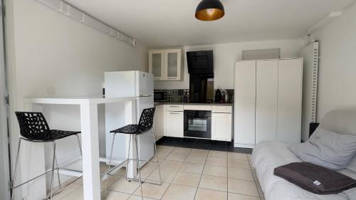 - une cuisine blanche avec un canapé, une table et des chaises dans l'établissement Studio centre Seignosse, à Seignosse