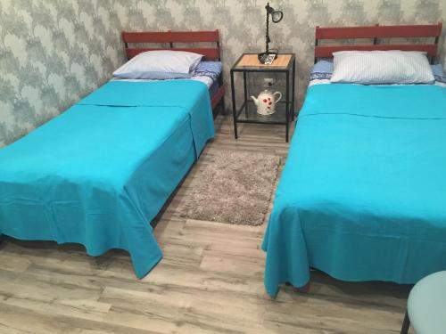 two beds with blue covers in a room at YELLOW UNLIMITED HOTEL 4 in Kharkiv