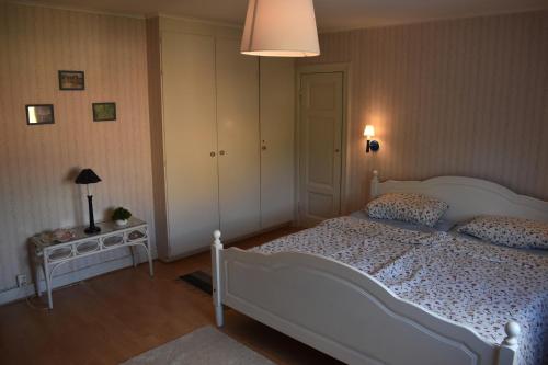 a bedroom with a white bed and a lamp at Hus Vena in Vena
