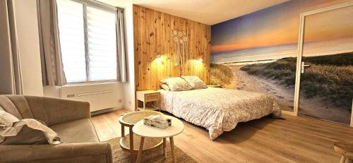 a bedroom with a bed and a painting of a beach at La Belle Maison in Avèze
