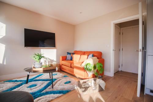 uma sala de estar com um sofá laranja e uma mesa em Dream Stays Bath - John Street em Bath