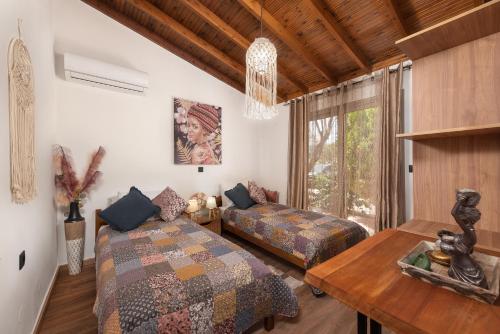 sypialnia z 2 łóżkami, stołem i oknem w obiekcie Ilaira Sea View Bungalow w mieście Jenadi