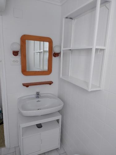 a white bathroom with a sink and a mirror at Victoria, 8-22 in Cullera