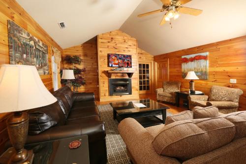 a living room with leather furniture and a fireplace at Cedar Falls by Eden Crest in Pigeon Forge